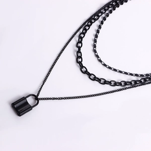 Detail view of a multi-layer black padlock necklace featuring three distinct chain styles