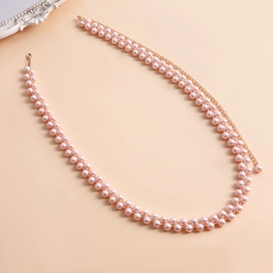 Dettaglio della catena corpo in perle rosa con chiusura a moschettone dorata e catena