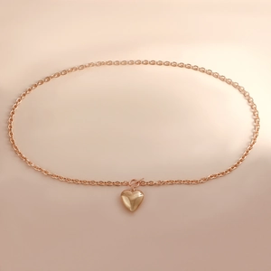 Detail of rose gold aluminum waist chain featuring toggle clasp and heart pendant