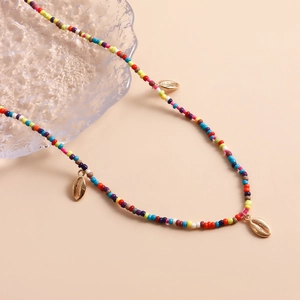 Detail of colorful seed bead necklace with gold shell charms and starfish beach style