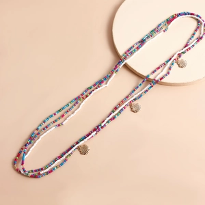 Detail of bohemian layered colorful bead necklaces with golden shell pendants for beach wear