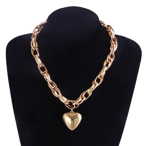 Detailed close-up of a chunky gold link chain necklace with a glossy heart pendant