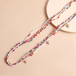 Macro detail of multi-layered colorful beads and gold turtle charms for beach body jewelry