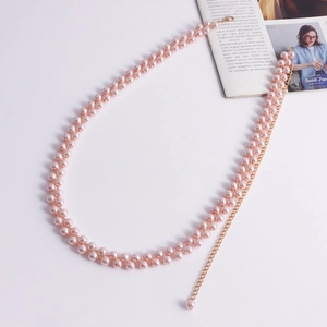 Dettaglio macro della catena da corpo a doppia fila di perle rosa con maglie d'oro regolabili