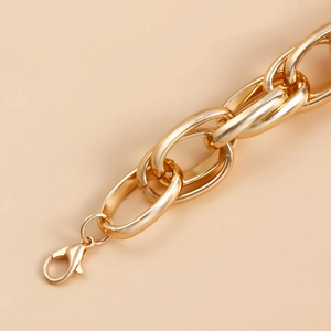 Macro detail of chunky gold link chain necklace with polished finish and lobster clasp