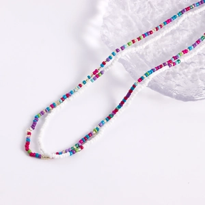 Detail of double-layer beaded necklace with colorful seed beads on ice-textured tray