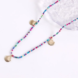 Detail of colorful beaded waist chain featuring golden shell charms in bohemian beach style