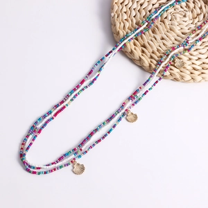 Detail view of colorful bead body chains with gold shell pendants on a white background