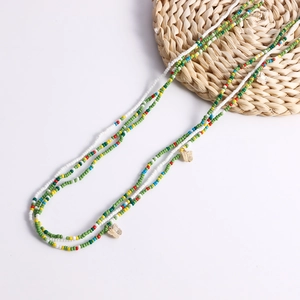 Detail of colorful seed bead body chain with gold butterfly pendants and boho style