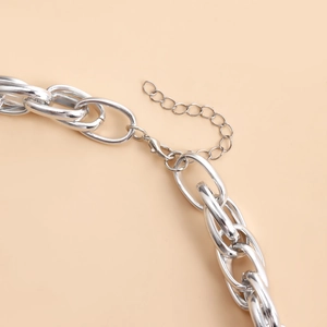 Detail view of silver metal chain necklace showing lobster clasp and extension link