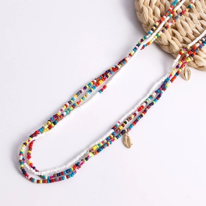 Detail of multi-colored seed bead body chain with gold shell charms on beach style jewelry