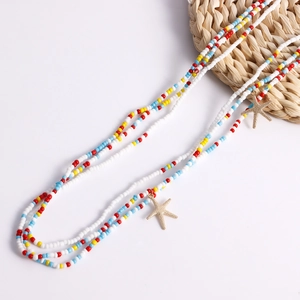 Detail of colorful beaded waist chains with golden starfish charms on white background