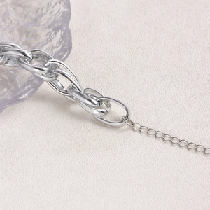 Close-up of chunky silver link chain with extension and mirror finish on rock surface