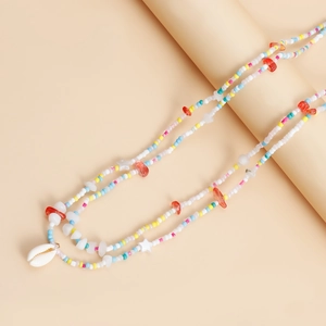 Detail of beach waist chain with colorful beads, starfish accents and a natural seashell pendant