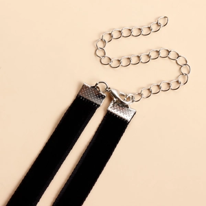 Dettaglio di choker in velluto nero con chiusura a moschettone argento e catenina