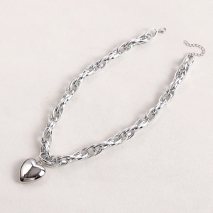 Macro shot of a thick silver-toned O-chain necklace with a bold heart pendant