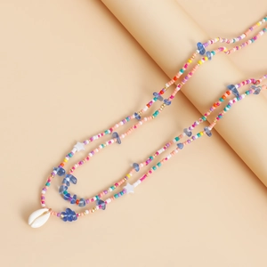 Detail of layered bohemian waist chain with colorful beads and natural cowrie shell
