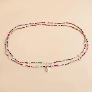 Detail of colorful beads beach body chain with natural shell pendant and star accents