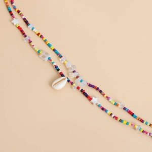 Detail of beaded waist chain with colorful beads, white stars and a natural seashell pendant