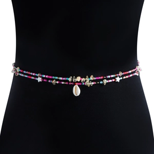 Detail of bohemian waist chain with colorful beads, gravel stones and a cowrie shell charm