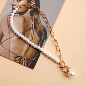 Detail of half pearl and gold chain necklace with OT clasp and sphere pendant