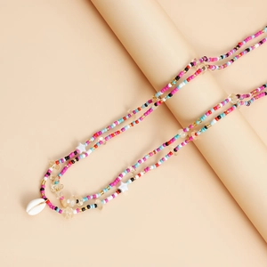 Macro detail of multi-color beaded body chain with a white shell and starfish charm