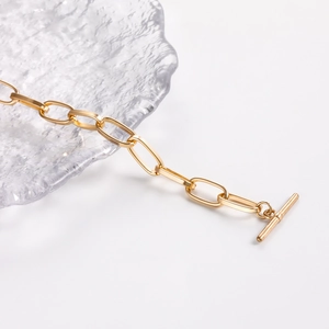 Detailed macro view of 18K gold paperclip link chain necklace with a classic toggle clasp