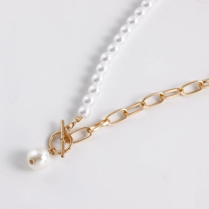 Detail of mixed pearl and gold link necklace featuring an elegant OT clasp and pendant