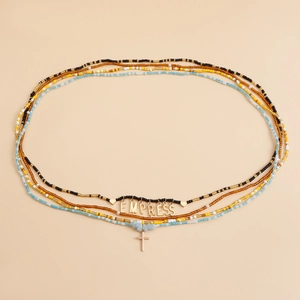 Detail of layered waist chains with beads, starfish charms and EMPRESS gold pendant