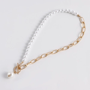 Close-up of pearl necklace with gold chain link, OT clasp and minimalist pendant detail