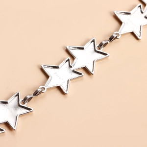 Detailed macro of silver star link chain showing metallic texture and engraved code