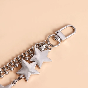 Detail of multi-layered silver metal jeans chain with polished star pendants and lobster clasp