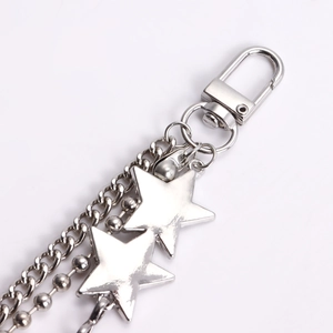 Close-up of multilayer silver metal trouser chain featuring star pendants and clasps