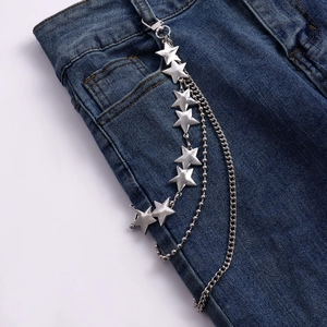Detail of layered silver metal pant chain with stars on denim jeans pocket