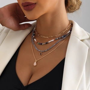 Collana multistrato bohémien con catene a graffetta dorate, perline colorate e ciondoli