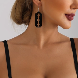 Close-up of punk black acrylic razor blade earrings worn on model for gothic style