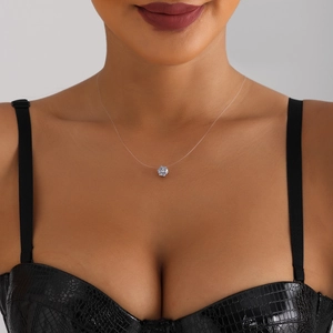 Minimalist zircon pendant necklace on invisible fishing line worn by female model