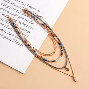 Dettaglio di una collana bohémien a strati con perline colorate e ciondoli a goccia