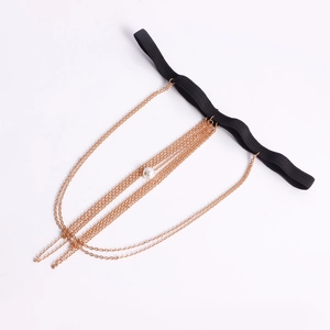 Dettaglio macro della catena da gamba dorata a strati con perla e fascia elastica