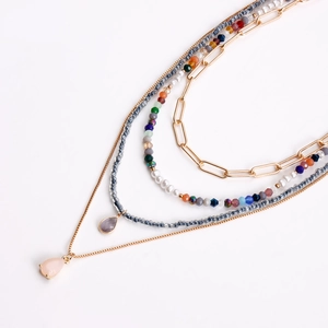 Dettaglio della collana bohémien a strati con catene dorate, perle e perline colorate
