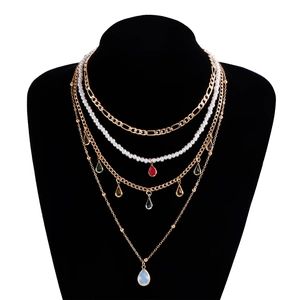 Dettaglio della collana bohémien a più strati con ciondoli colorati e perle finte