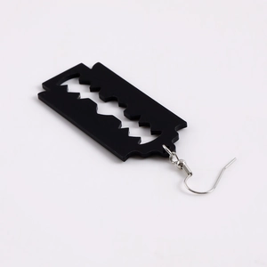 Detailed macro view of black matte acrylic razor blade earrings with silver hooks
