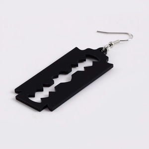 Close-up of black acrylic razor blade pendant with silver metal hook earring