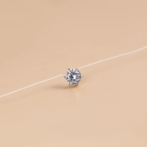 Macro detail of a floating zircon pendant on a transparent nylon invisible fishing line