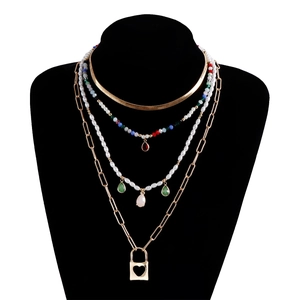 Dettaglio di collana bohémien a quattro strati con perline colorate, perle e cuore apribile