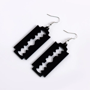 Detailed view of creative black acrylic razor blade earrings with silver metal hooks
