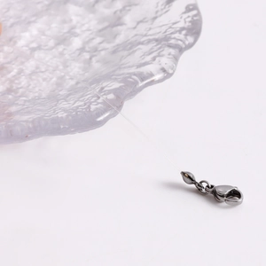 Detail of gray metal lobster clasp and jump ring on transparent crystal fishing line
