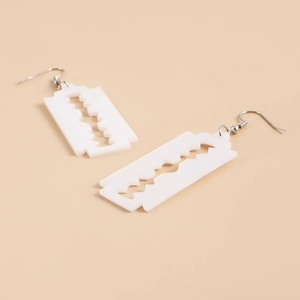 Detail shot of white acrylic razor blade drop earrings with silver metal hooks