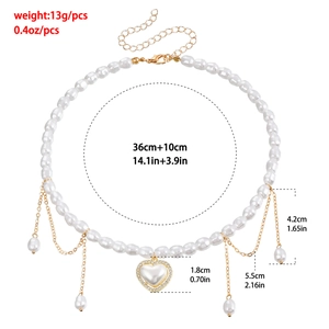 Franse vintage parelketting met hart, gouden kwastjes en afmetingen op witte achtergrond