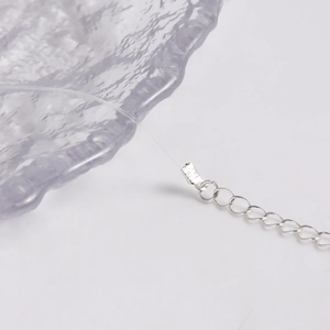 Detail of transparent nylon fish line necklace with adjustable silver extension chain